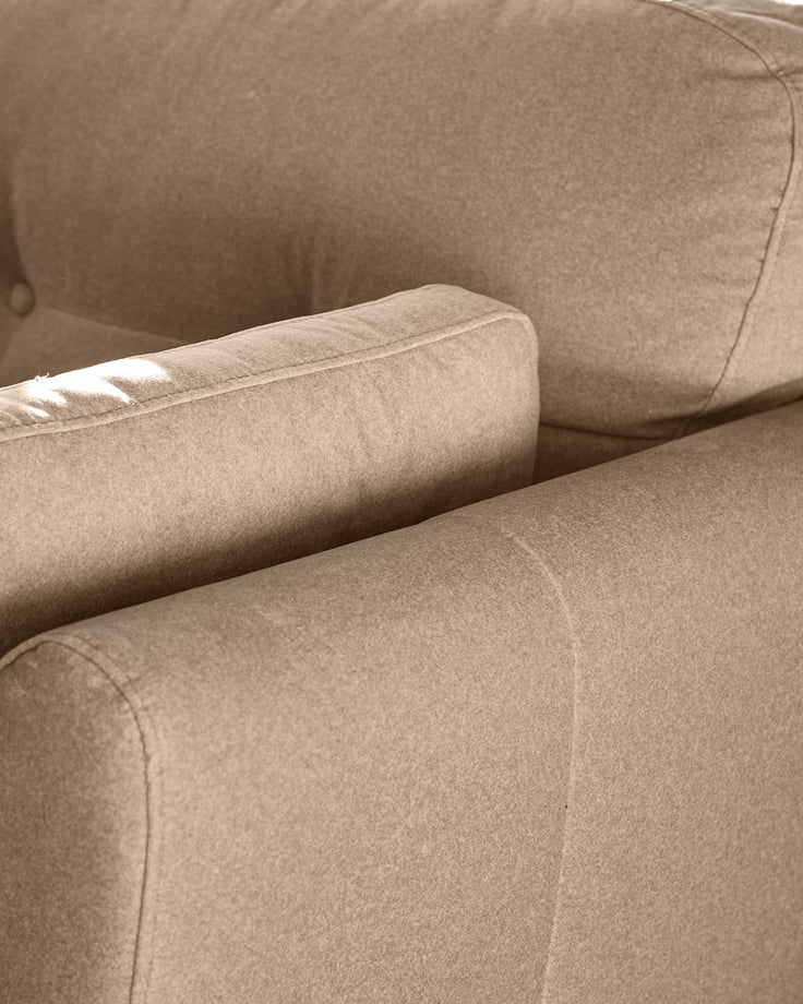 Delilah Armchair in mocha fabric, close-up detail of rolled arm and seaming.