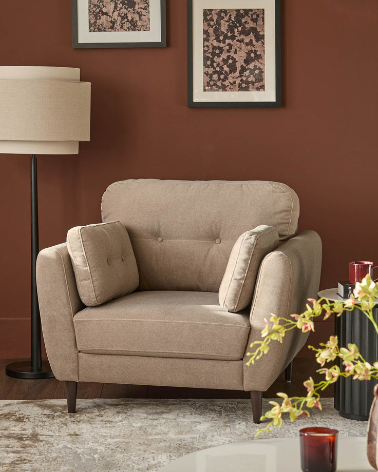 Delilah mocha fabric armchair with rolled arms, button tufting, and wooden legs in a styled living room setting.