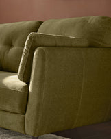Delilah 3-seater sofa in pistachio green fabric, showing close-up of rolled armrest and cushioned seating from side angle.