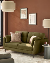 Pistachio green 3-seater sofa with rolled arms and tapered legs, styled in a terracotta-walled living room setting.
