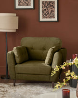 Delilah armchair in pistachio green fabric with button-tufted back, paired arms, and dark wooden legs, styled in a warm terracotta room.