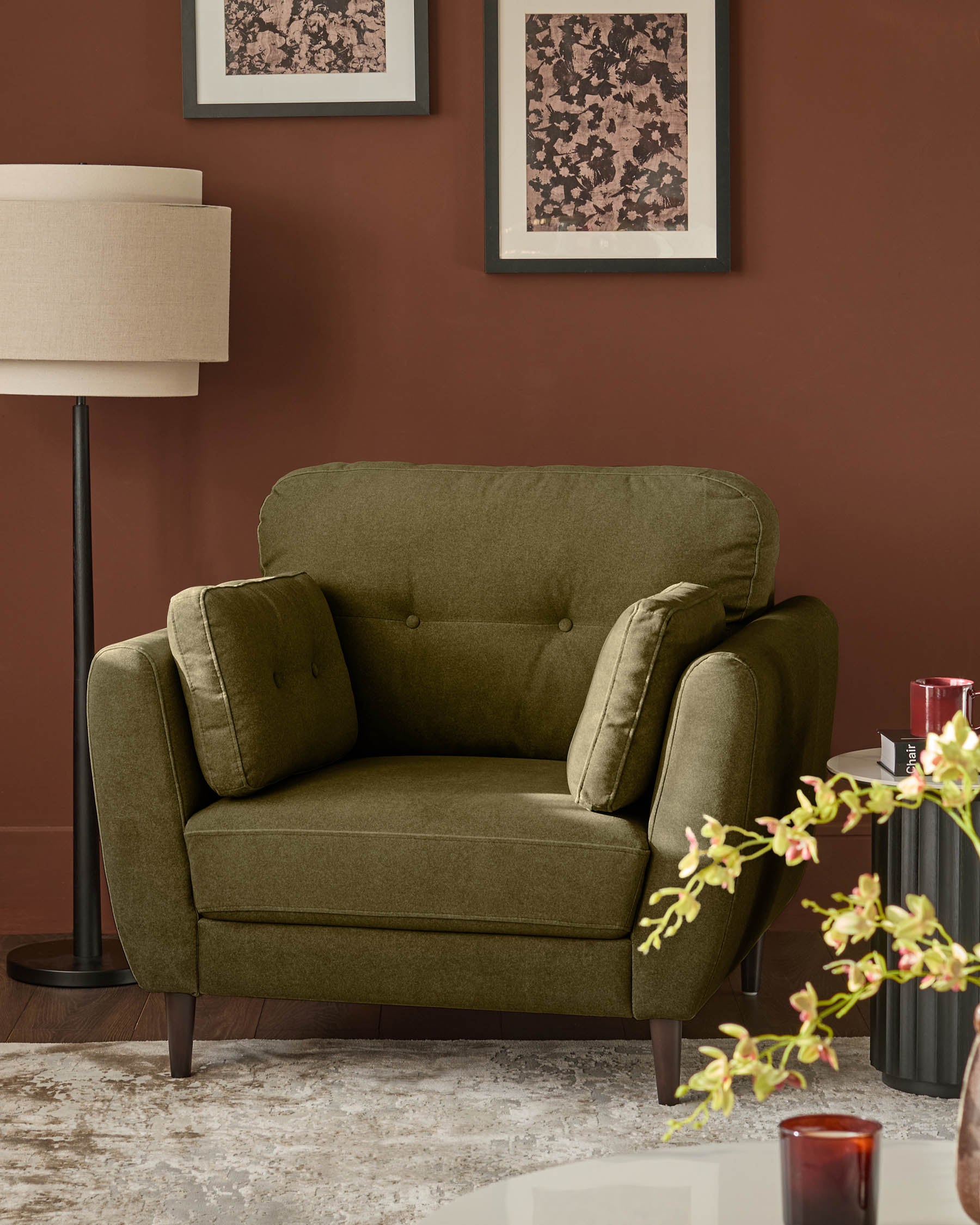 Delilah armchair in pistachio green fabric with button-tufted back, paired arms, and dark wooden legs, styled in a warm terracotta room.