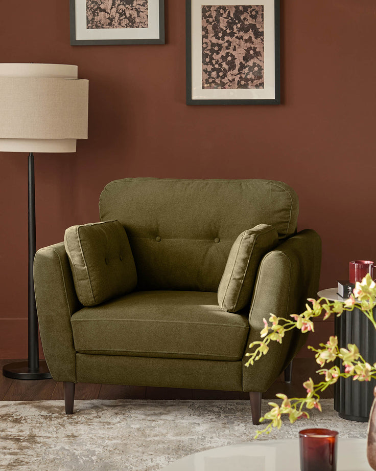 Delilah armchair in pistachio green fabric with button-tufted back, paired arms, and dark wooden legs, styled in a warm terracotta room.