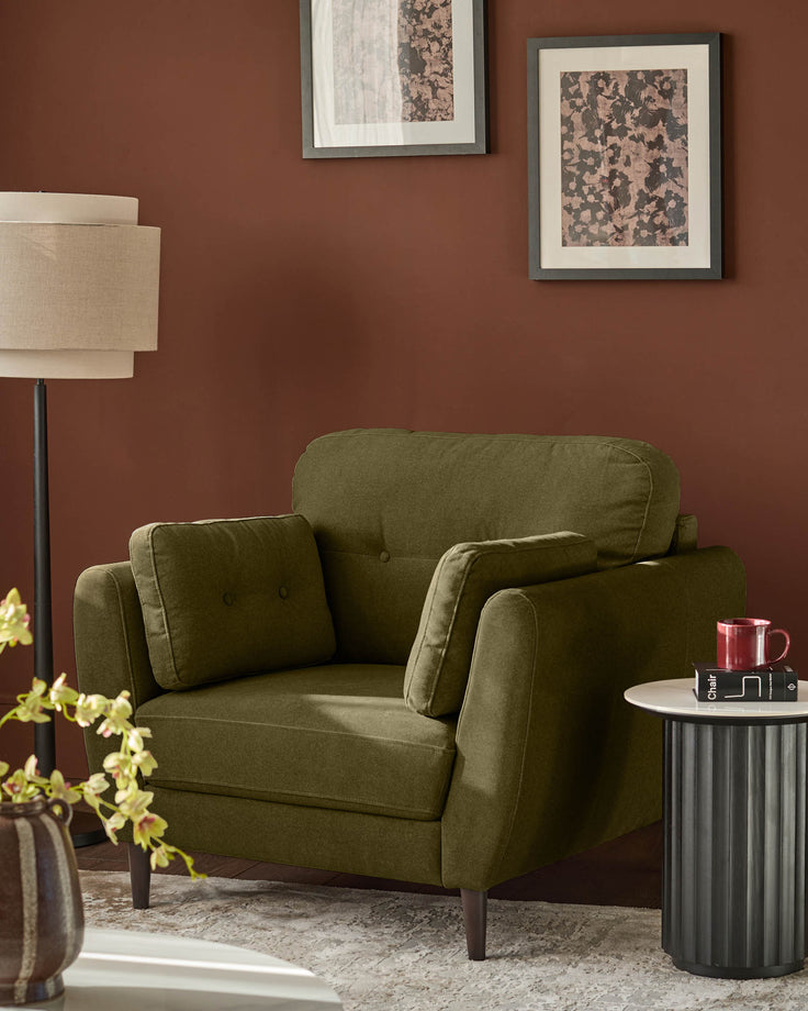 Pistachio green upholstered armchair with rolled arms, button-tufted back, and dark wooden legs in a rust-colored room setting.
