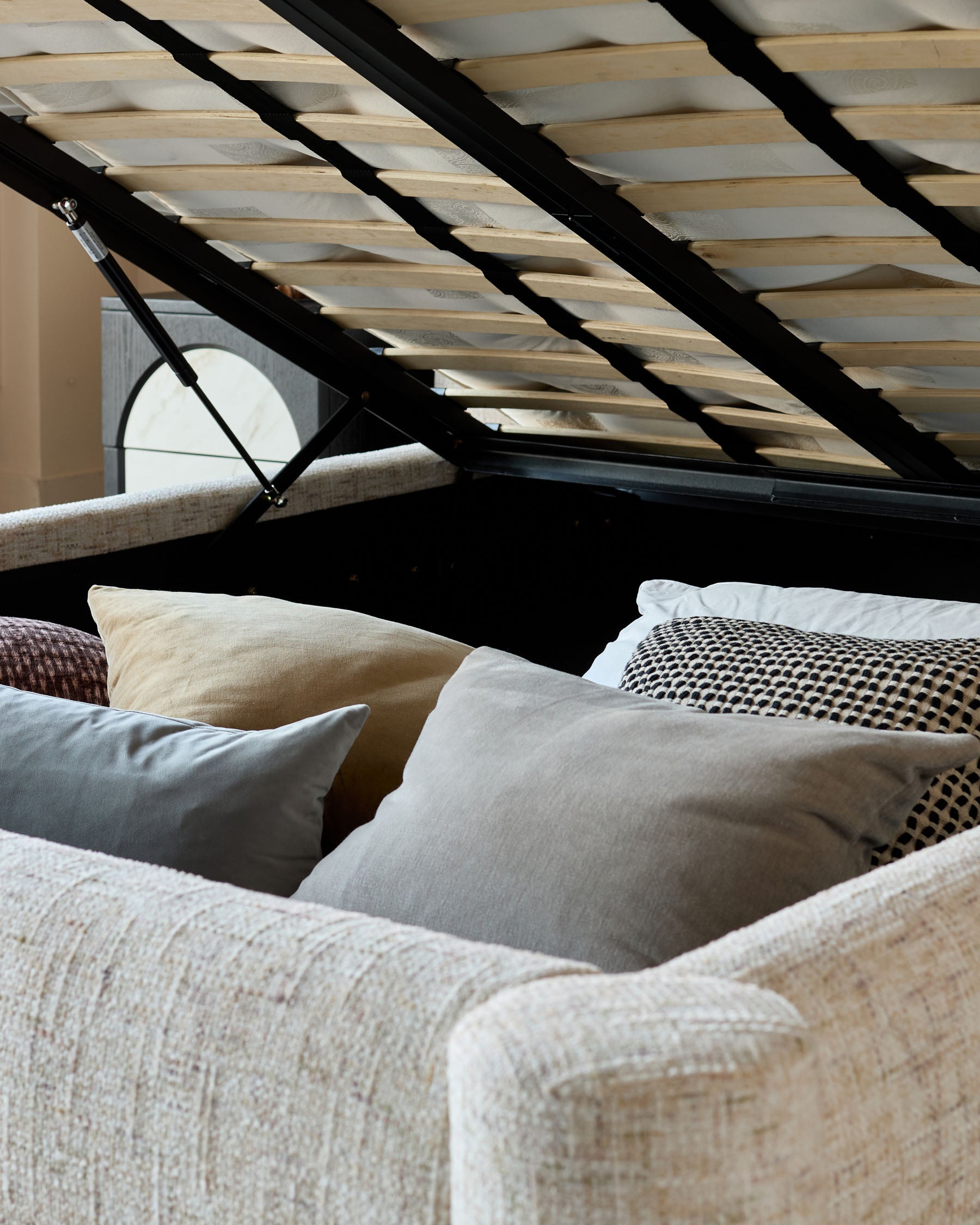 Deven King-Size Ottoman Bed in natural fabric, shown open with wooden slats and storage compartment visible.