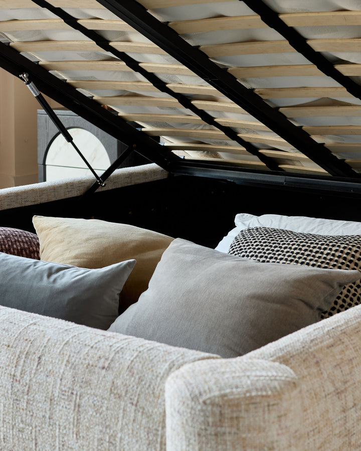 Deven King-Size Ottoman Bed in natural fabric, shown open with wooden slats and storage compartment visible.