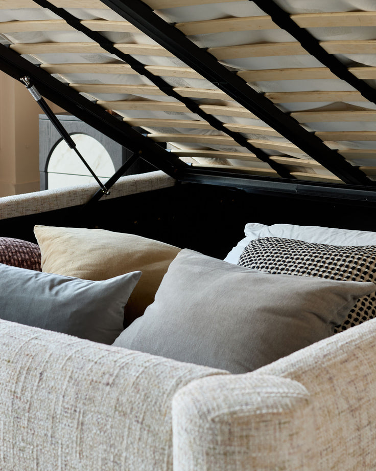 Deven King-Size Ottoman Bed in natural fabric, shown open with wooden slats and storage compartment visible.