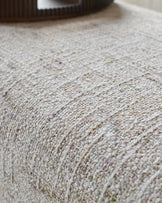 Close-up of natural beige textured fabric on Deven bench, showing woven surface detail.
