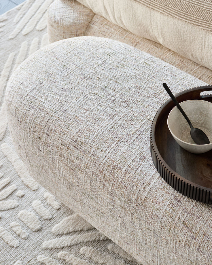Deven bench in natural fabric with textured weave, styled with a wooden bowl and black spoon on top.