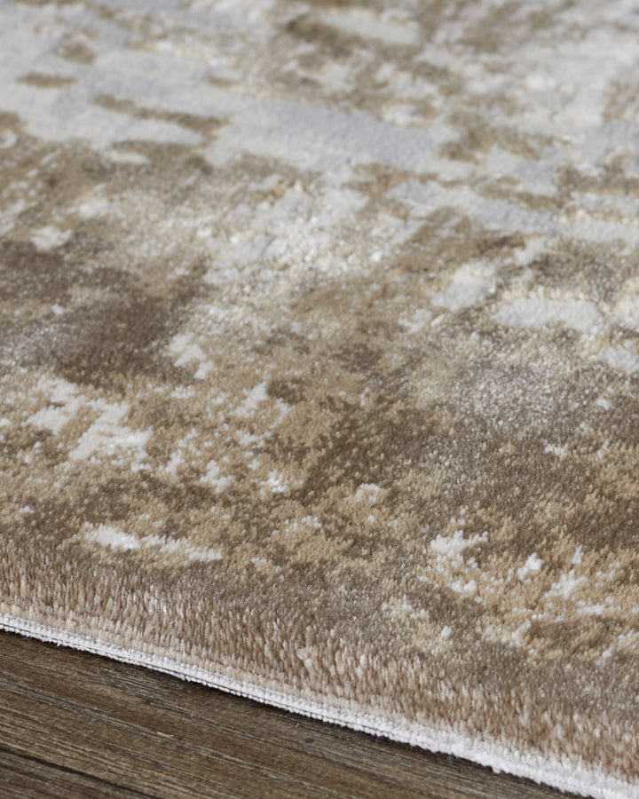 Close-up of distressed border textured rug in natural beige and cream tones showing pile detail and white binding edge.