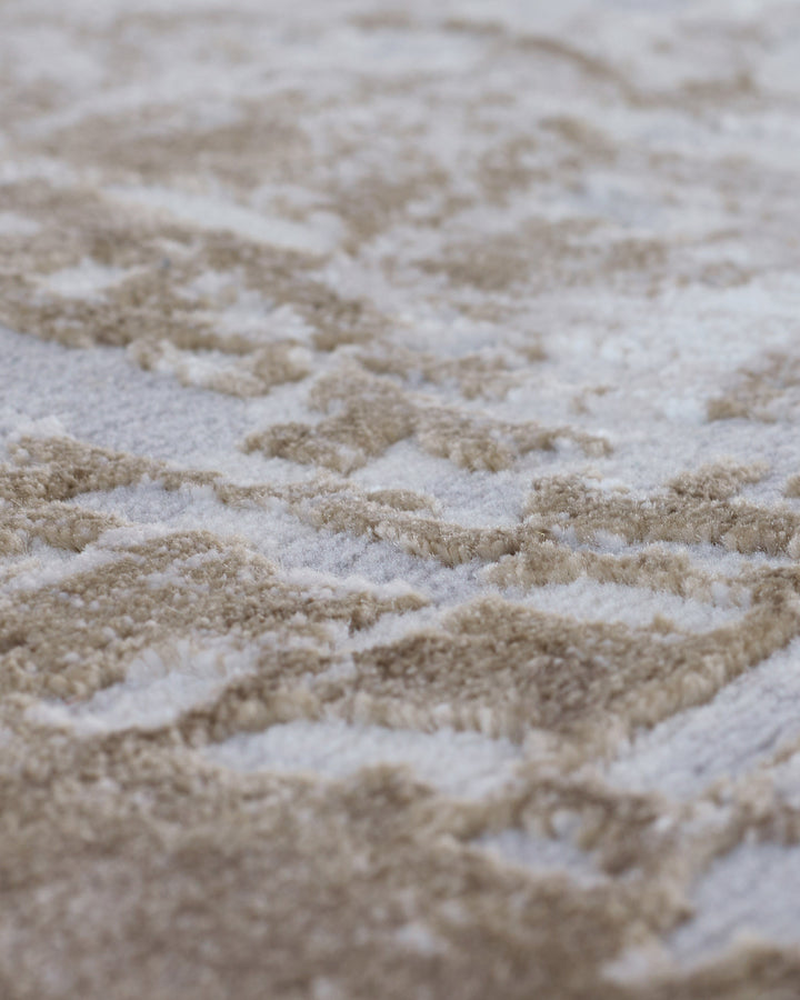 Close-up of distressed border small rug in natural beige and cream textured weave detail.