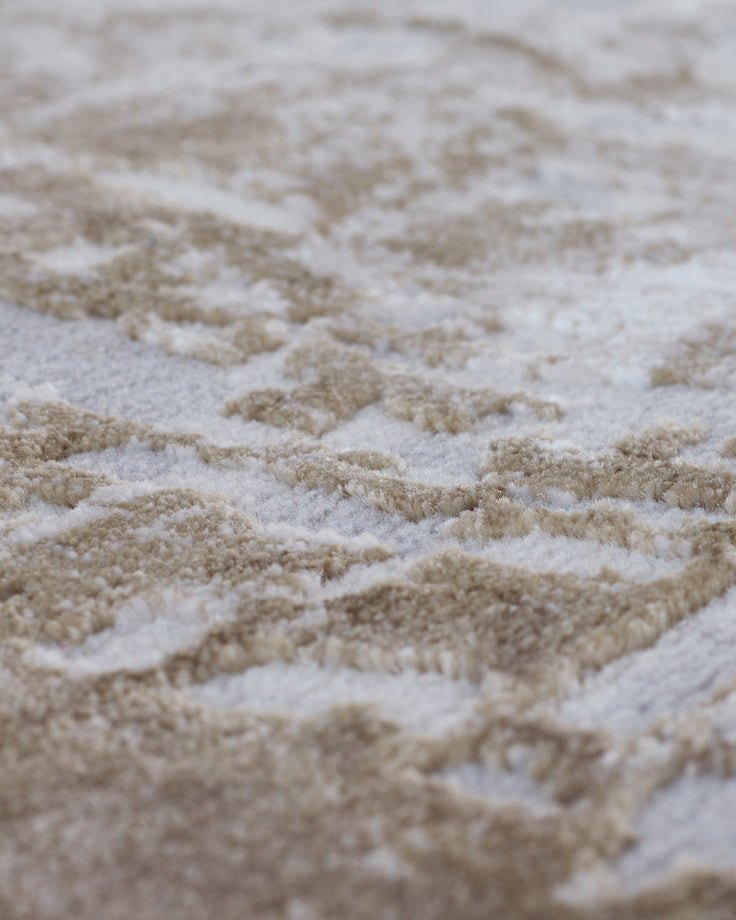Close-up of distressed border small rug in natural beige and cream textured weave detail.