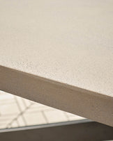 Close-up of concrete tabletop surface showing speckled light grey finish and edge detail with metal frame.