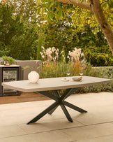 Donato garden dining table with dark grey spider-leg base and light grey top, styled in outdoor patio setting.