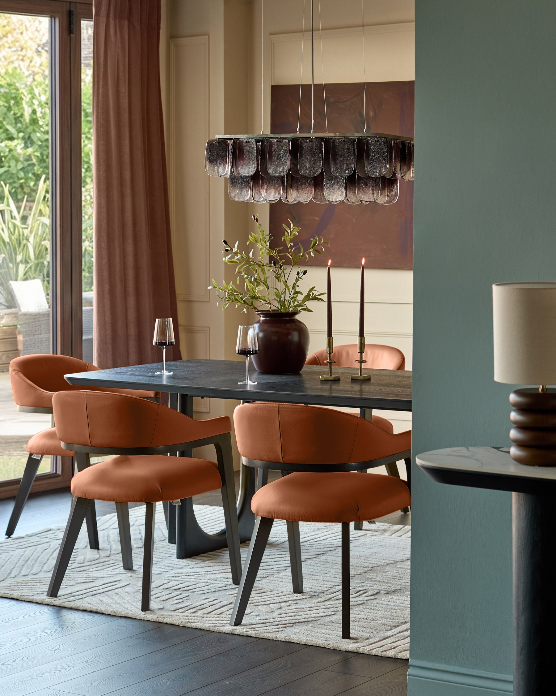 Dylan dining chair in tan leather, curved back design, dark wood legs, shown in dining room setting.