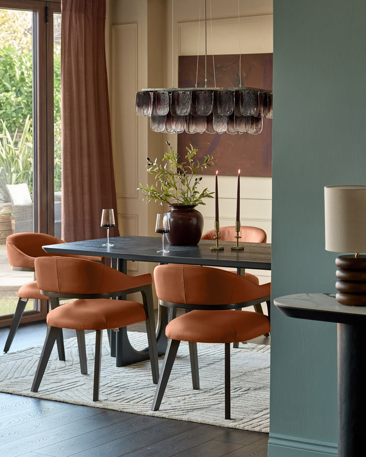 Dylan dining chair in tan leather, curved back design, dark wood legs, shown in dining room setting.