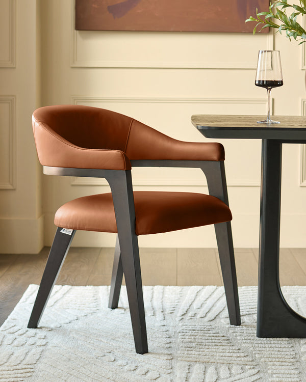 Dylan dining chair in tan leather with charcoal wood frame, shown at an angle beside a black pedestal table with wine glass.
