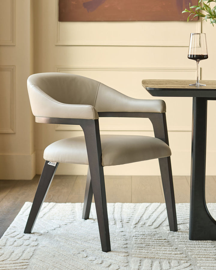 Dylan dining chair in natural leather with dark wood legs, shown at an angle next to a small black table.