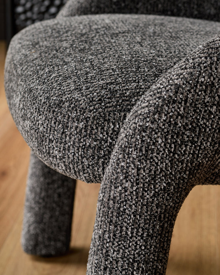 Easton dining chair in dark grey fabric, close-up detail of textured upholstery and curved leg.