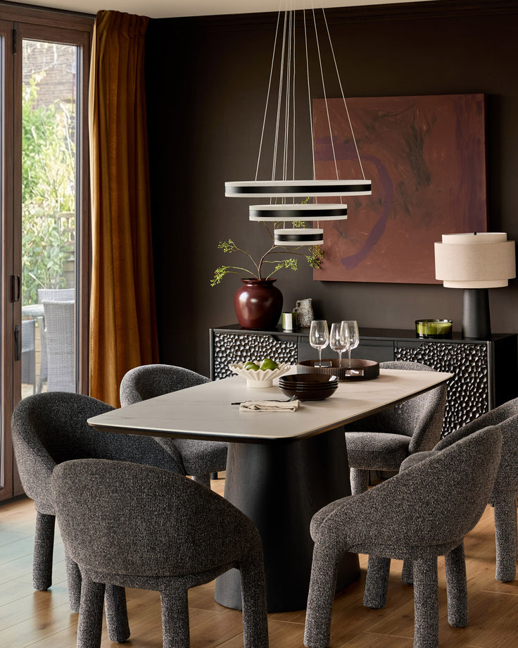 Easton dining chair in dark grey fabric, shown in modern dining room setting around light wood table.