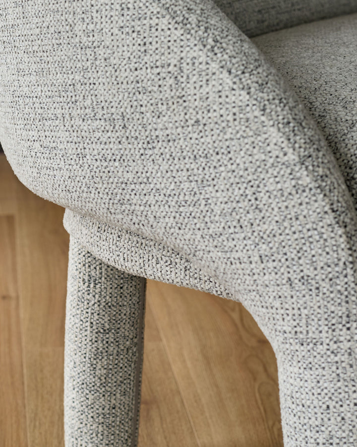 Easton Dining Bench in light grey fabric, close-up detail showing textured weave and wooden leg support.