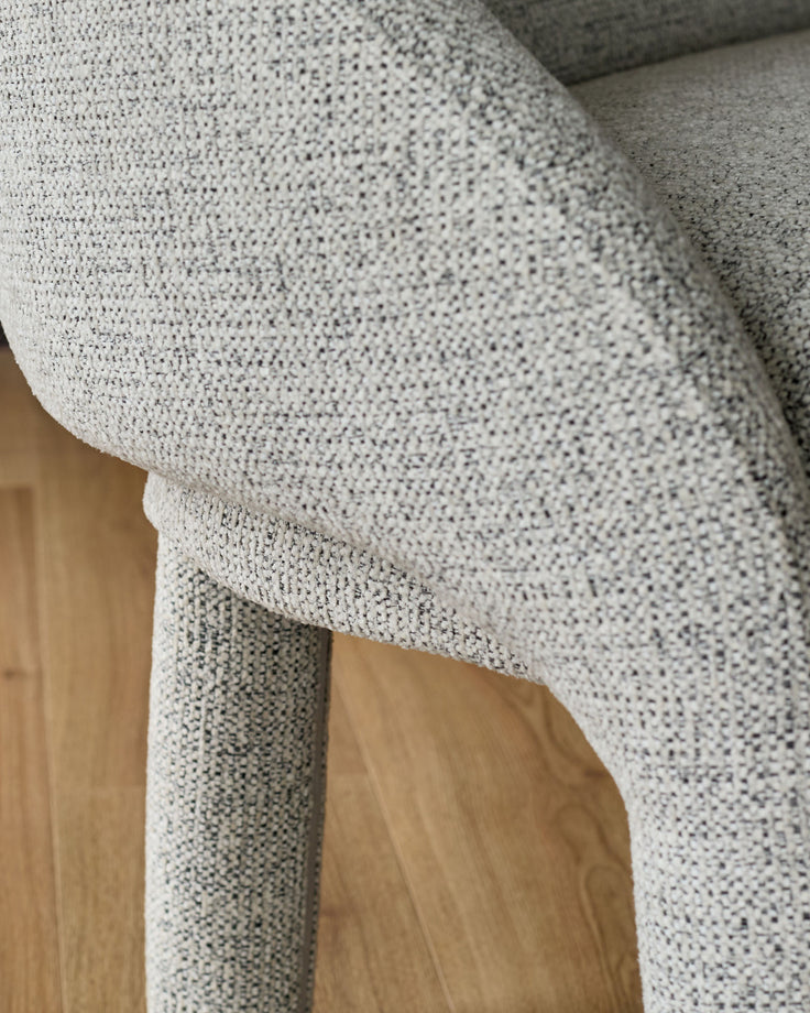 Easton Dining Bench in light grey fabric, close-up detail showing textured weave and wooden leg support.
