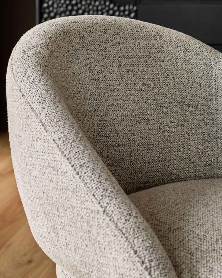 Easton dining chair in light grey fabric, close-up of curved backrest and armrest detail showing textured weave.