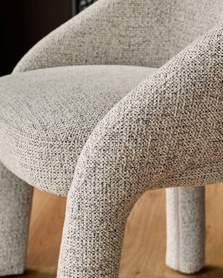 Easton dining chair in light grey fabric, close-up detail showing textured weave and wooden legs.