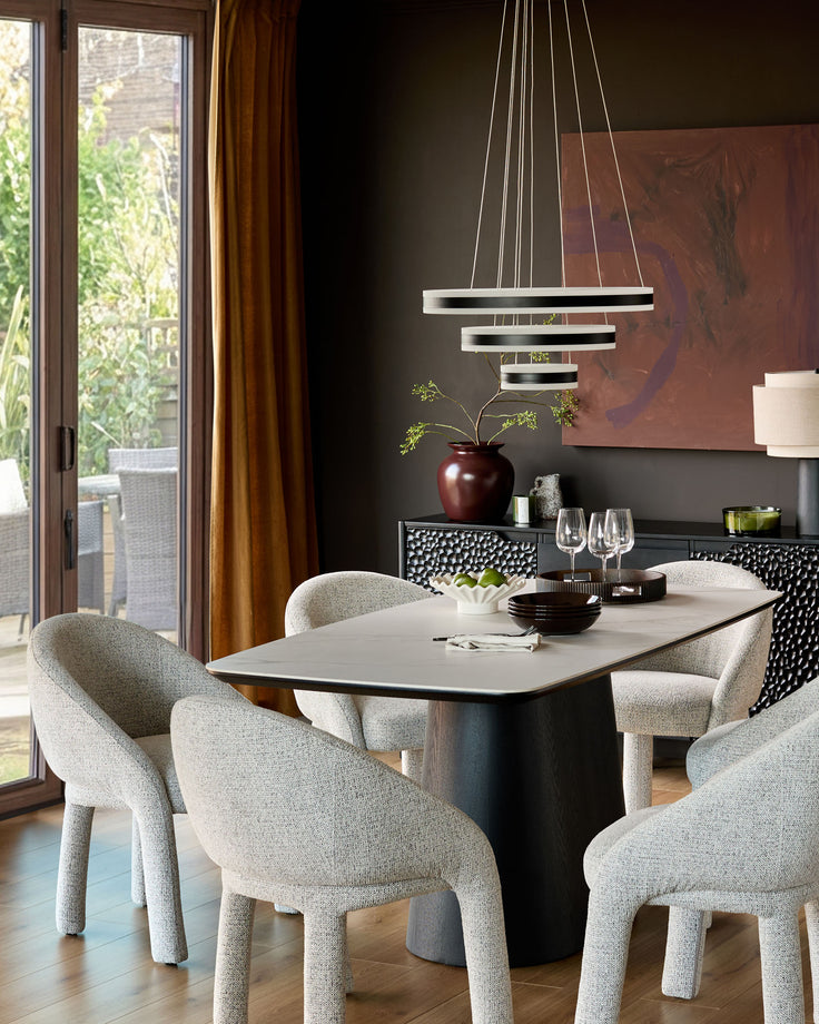 Easton dining chair in light grey fabric, shown in a modern dining room setting around a table.