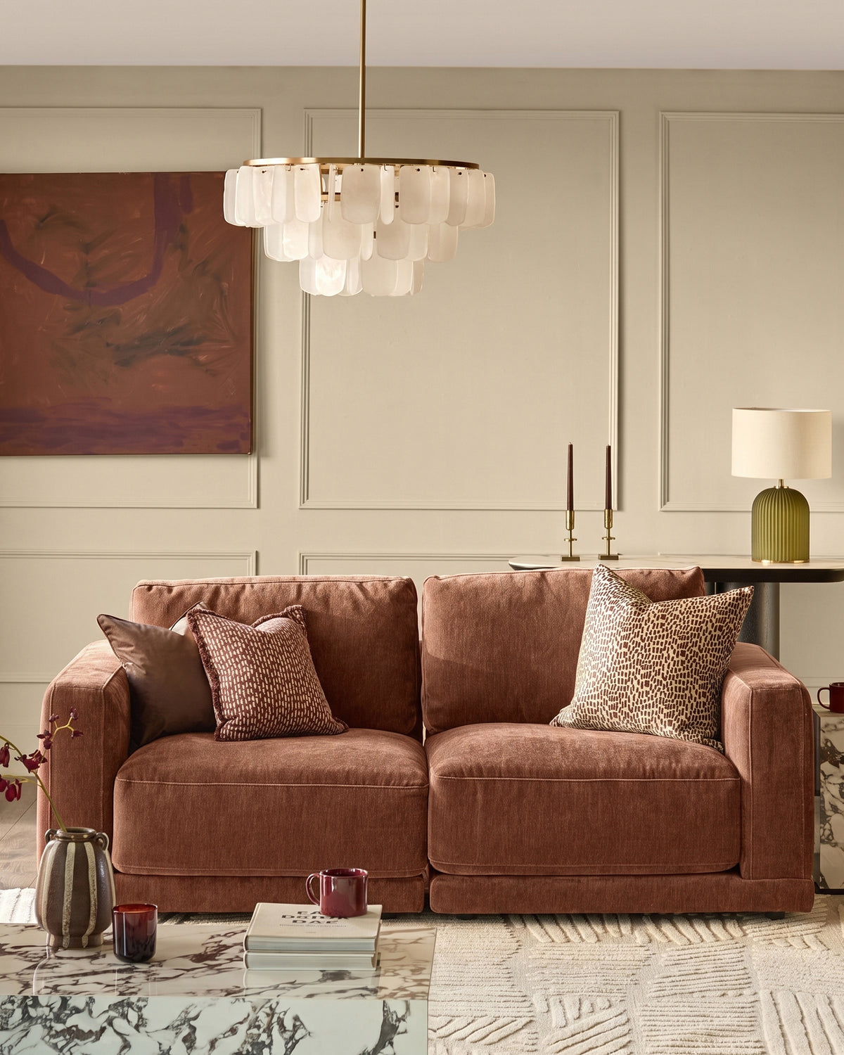 Eden two-seater sofa in apricot fabric, displayed in a styled living room setting with decorative pillows and accessories.