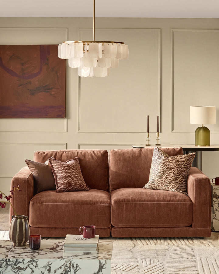 Eden two-seater sofa in apricot fabric, displayed in a styled living room setting with decorative pillows and accessories.