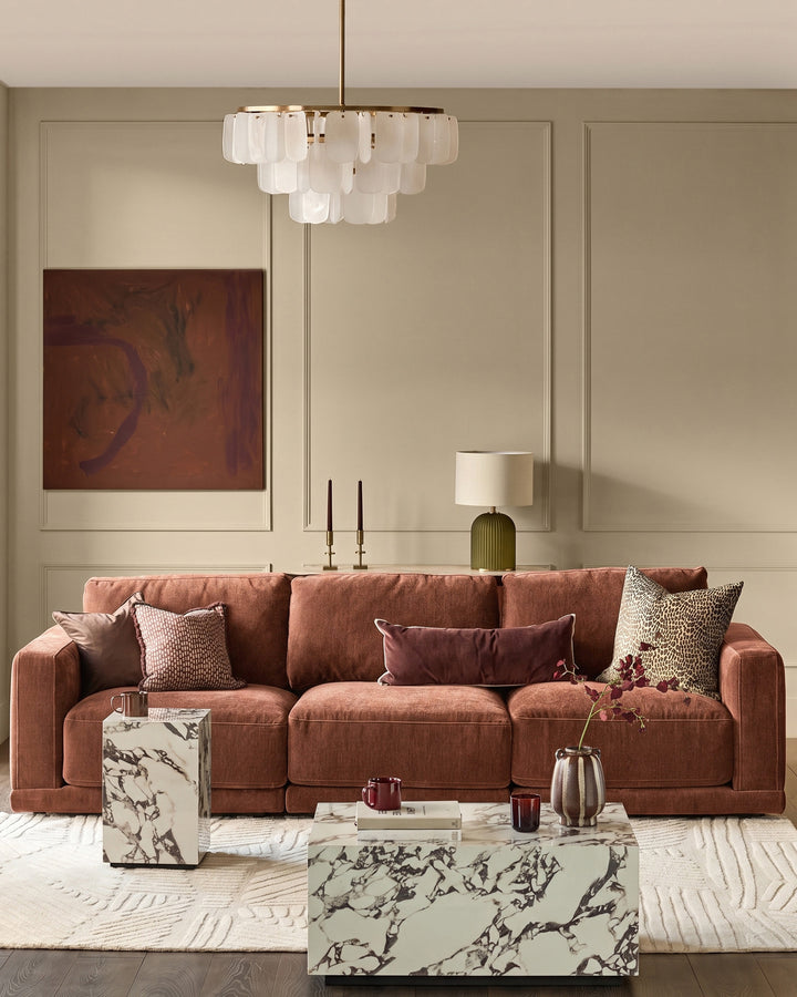Eden 3-seater sofa in apricot fabric, styled in a modern living room with decorative pillows and marble coffee table.