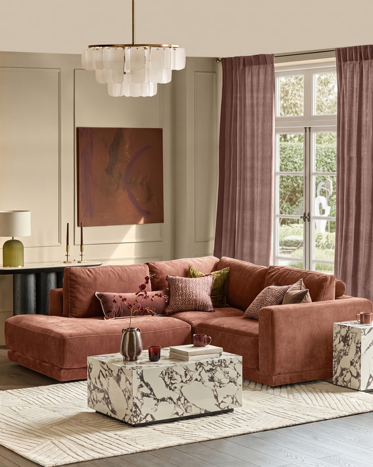 Eden left small chaise sofa in apricot fabric, styled in a modern living room with accent pillows and marble coffee table.