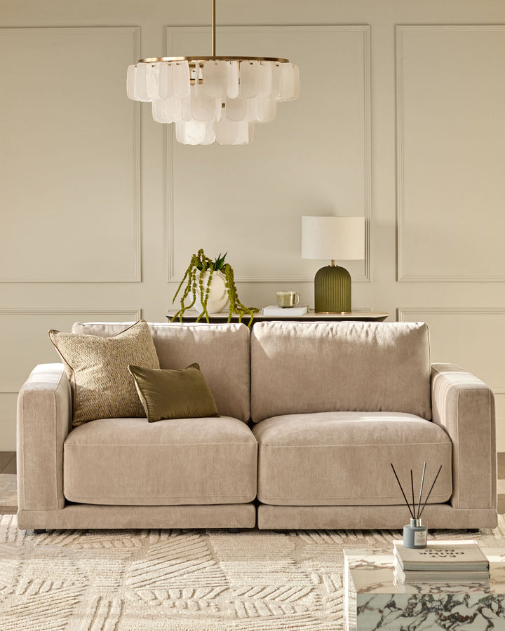 Eden 2-seater sofa in champagne fabric, displayed in a neutral living room setting with decorative pillows and styled accessories.
