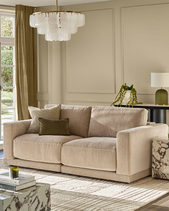 Eden 2-seater sofa in champagne fabric, displayed in a bright living room with neutral décor and modern styling.