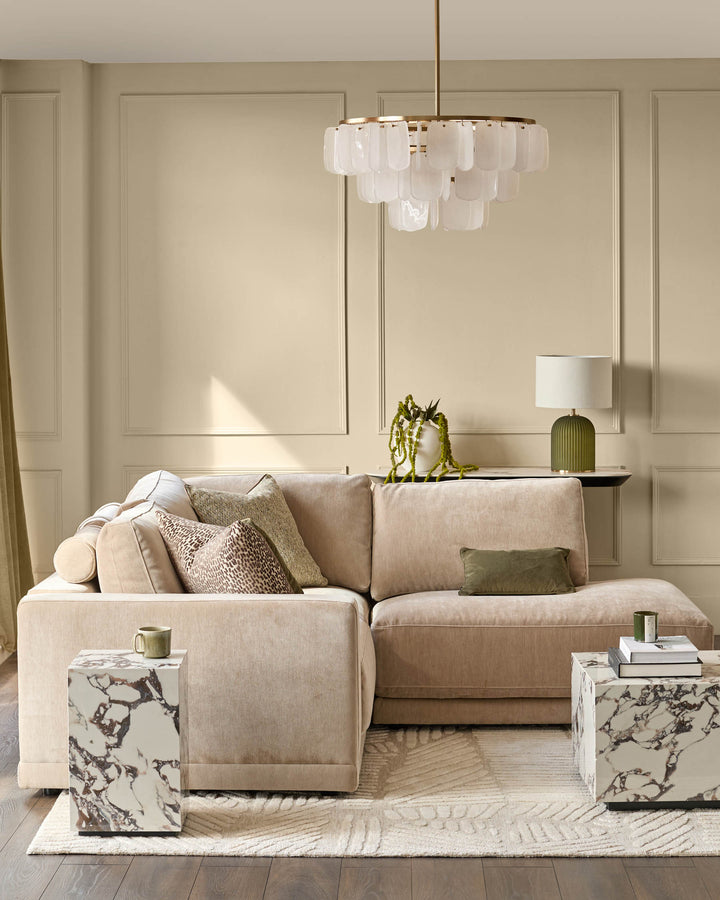 Eden right small chaise sofa in champagne fabric, styled in a neutral living room with decorative pillows and marble side tables.