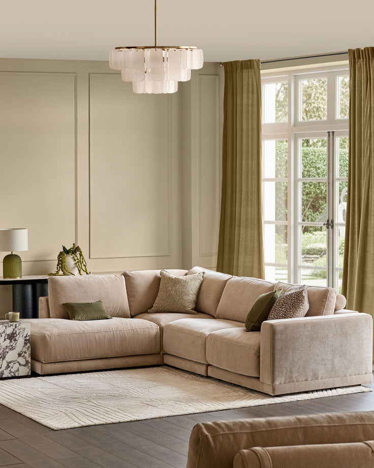Champagne fabric left-facing sectional sofa with chaise lounge in a bright, neutral living room setting.