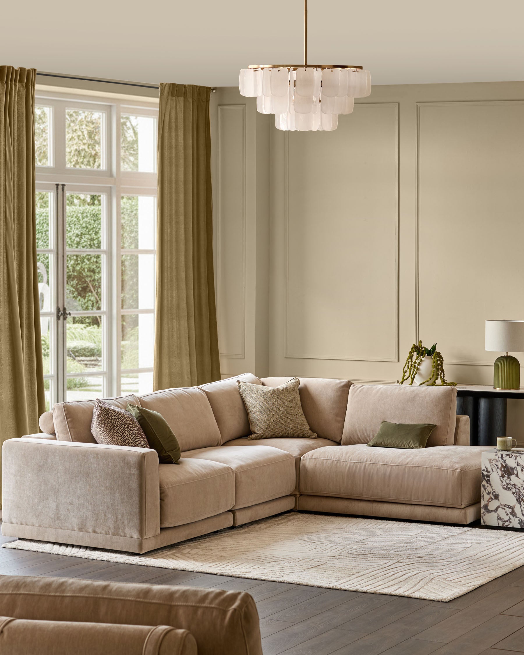 Eden right-facing large chaise sectional sofa in champagne fabric in a light-filled living room setting.
