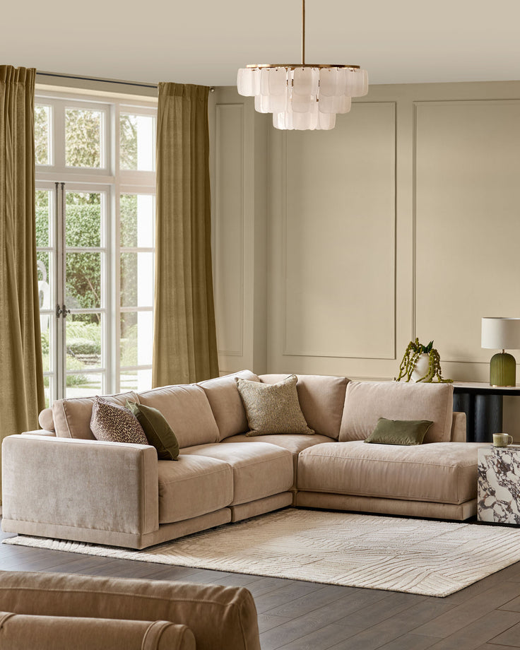 Eden right-facing large chaise sectional sofa in champagne fabric in a light-filled living room setting.