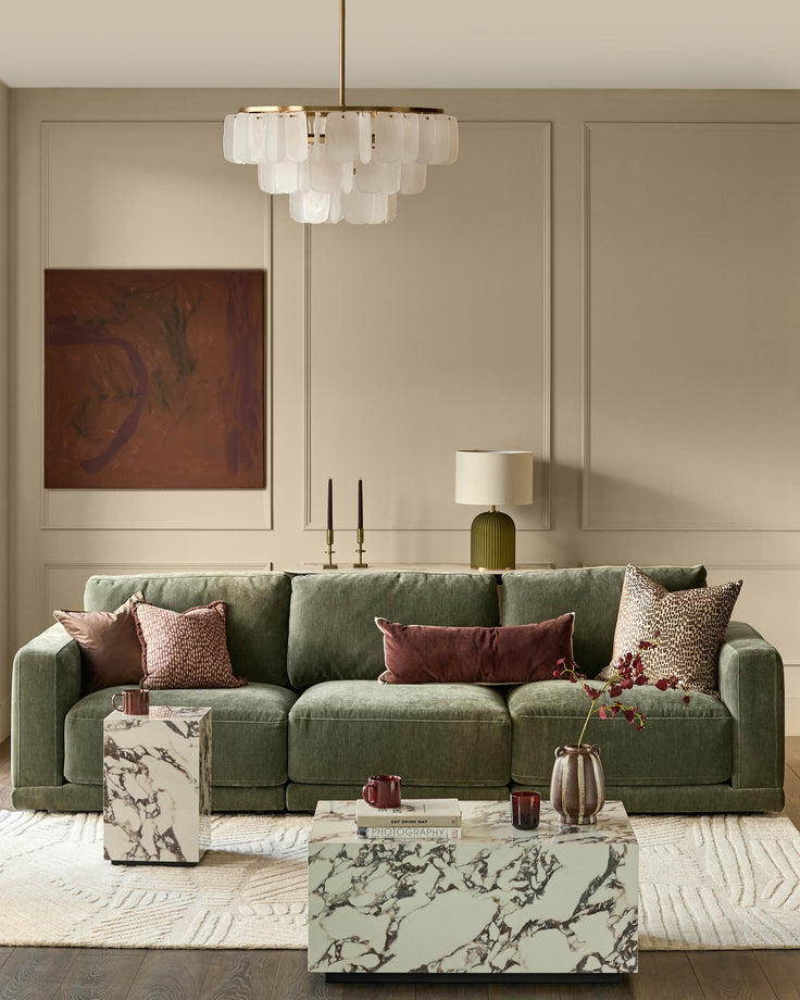 Eden 3-seater sofa in dark green fabric, displayed in a modern living room setting with decorative pillows.