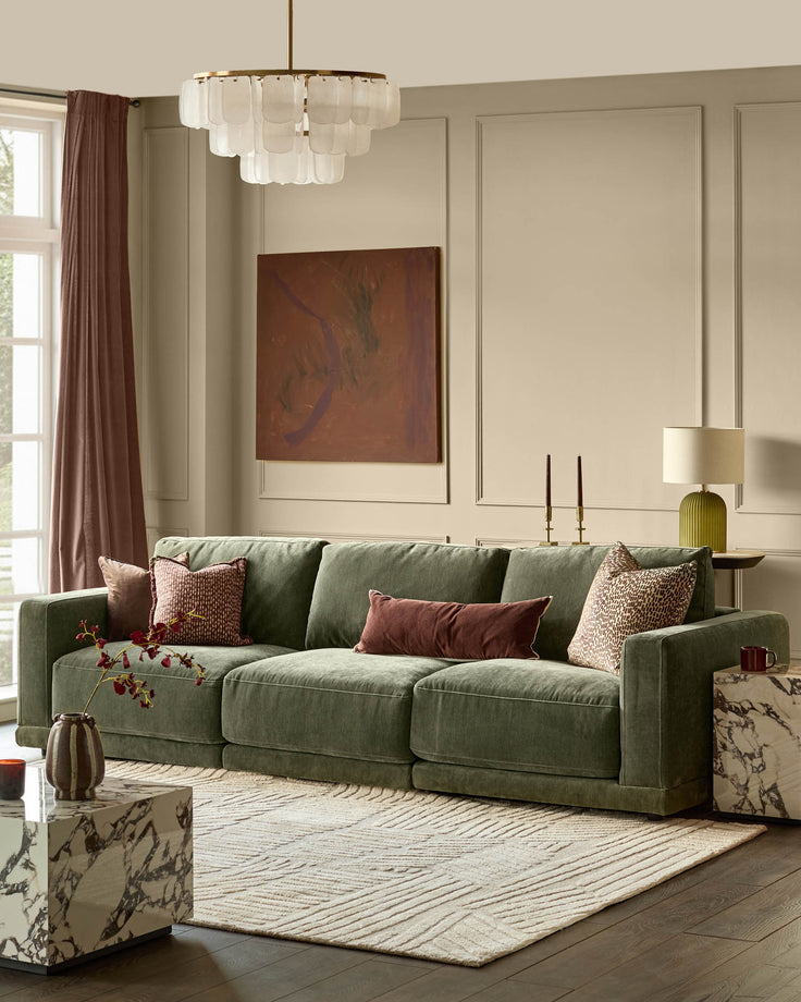 Eden 3-seater sofa in dark green fabric, displayed in a bright living room with decorative pillows and neutral décor.