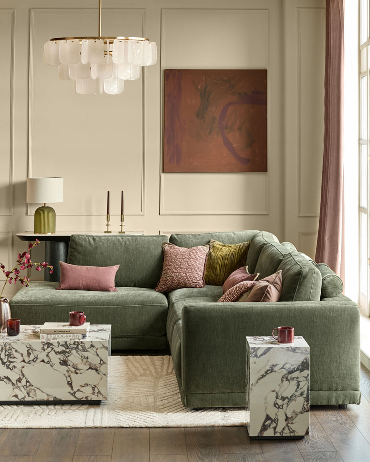 Eden left large chaise sofa in dark green fabric, styled in a modern living room with decorative pillows.