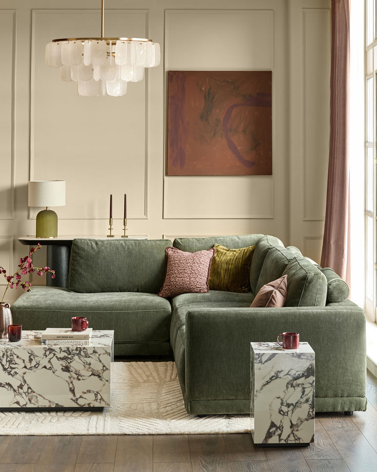 Dark green left-facing chaise sectional sofa with curved arms and plush cushioning, styled in a modern living room.