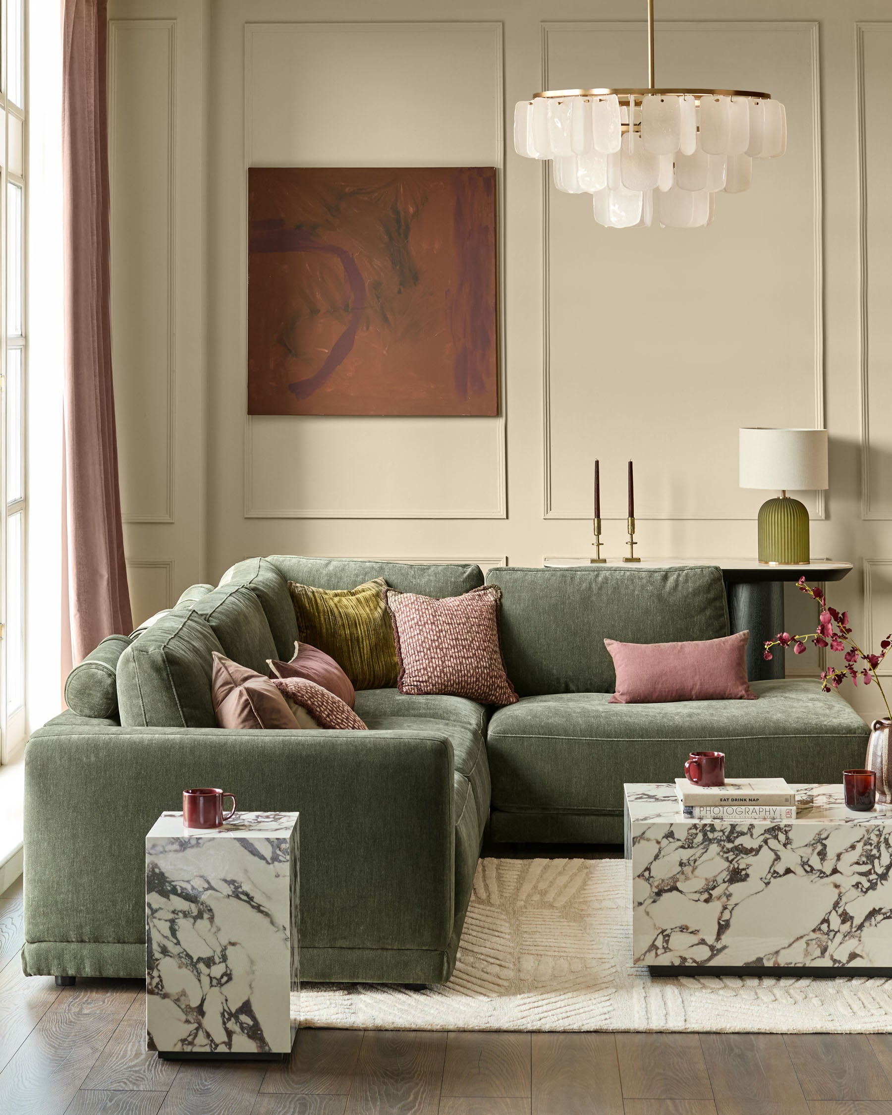 Dark green fabric right-facing large chaise sectional sofa with rolled arms and multiple decorative pillows in a styled living room.