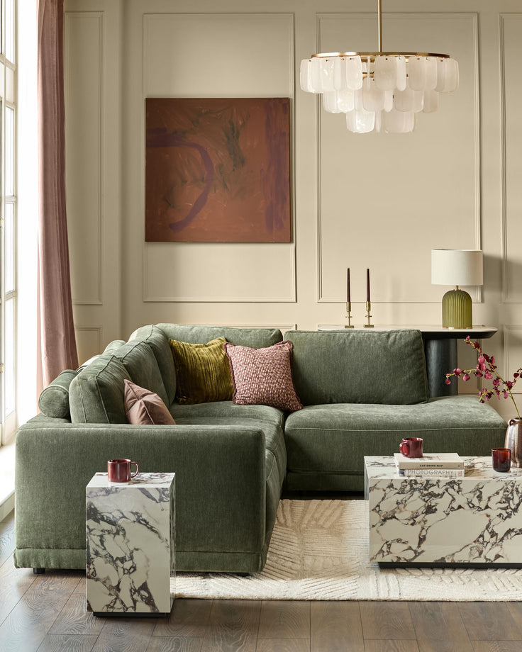 Eden right-facing large chaise sofa in dark green fabric, displayed in a styled living room setting with decorative pillows.
