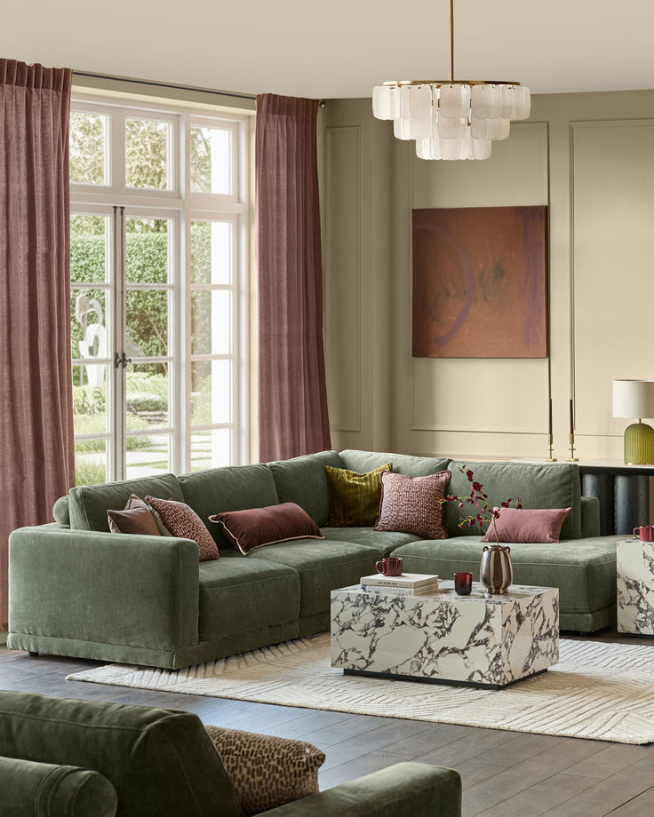 Dark green right-facing sectional sofa with chaise lounge, displayed in a modern living room setting with decorative pillows.