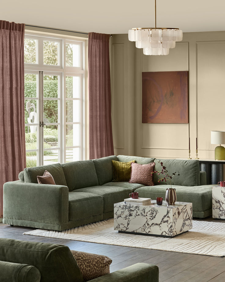 Dark green fabric right-facing sectional sofa with chaise lounge in modern living room setting.