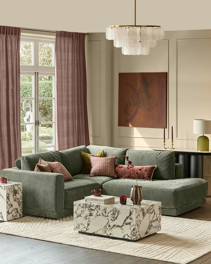 Dark green fabric right-facing chaise sectional sofa with curved arms, displayed in a styled living room setting.