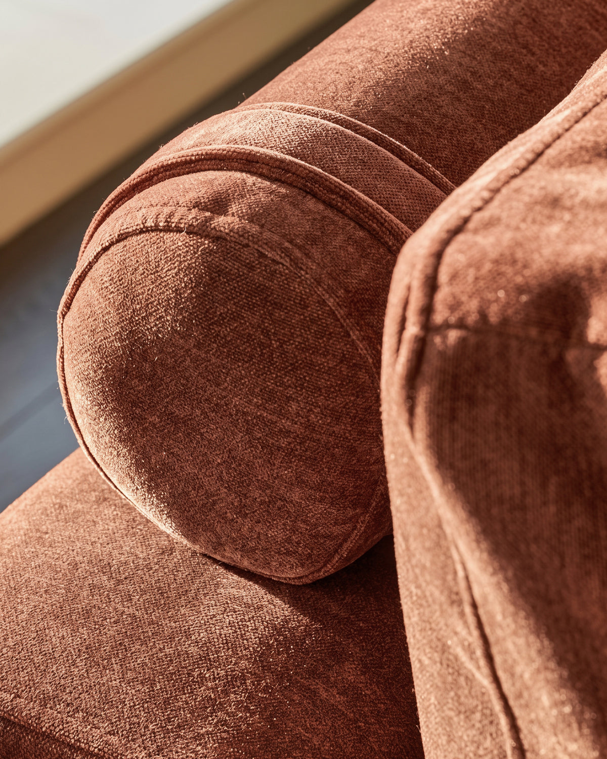 Close-up detail of Eden 2-seater sofa in apricot fabric, showing textured weave and rounded armrest piping.