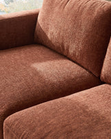 Eden 2-seater sofa in apricot fabric, close-up detail showing seat cushion and backrest texture.